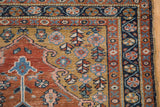 Evenly worn corner of a vintage Heriz rug with a gold spandrel and navy floral border.