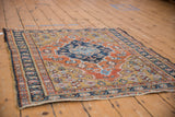Angled view of a vintage Heriz rug showcasing its navy medallion and intricate geometric patterns.