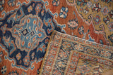 Flipped corner of a vintage Heriz rug revealing the low pile and hand-knotted foundation.