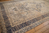 Distressed texture and faded navy Four Season Garden border of a Kerman carpet.