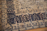 Distressed vintage Kerman carpet detail: navy Four Season Garden border with a subtle blush ivory field.