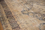 Distressed Kerman carpet's main border featuring worn dark navy millefleur motifs on antique ivory.
