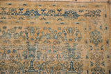 Gold and blue distressed Persian Meshed rug showing tree of life, bird motifs, mostly even wear.