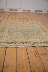 Distressed gold and dusty blue Meshed rug border with visible wear and fringe.