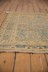 Distressed Meshed rug corner, showcasing faded gold and dusty blue tree of life patterns with wear.