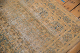 Distressed vintage Meshed rug detail, with gold field, faded blue floral motifs, and visible foundation.