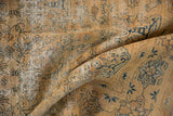 Distressed texture of vintage Meshed rug, gold pile, faded blue tree-of-life motifs, visible foundation.