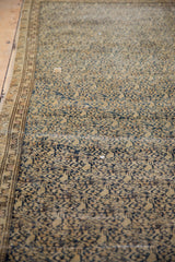 Antique Malayer rug's distressed navy blue lattice pattern over beige ground with worn border.