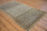 Antique Malayer rug displaying distressed texture, navy botehs, beige ground, and overall wear.