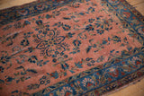 Antique Kashan rug's dusty rose field featuring intricate cobalt vinery, blossoms, and classic floral border.
