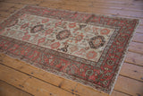 Worn Hamadan rug detail with terracotta rectilinear vine border and floral guls.