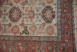 Distressed vintage Hamadan rug border detail: terracotta meandering floral vine, ivory field.