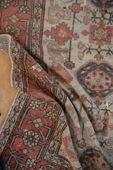 Distressed Hamadan rug pile with visible wear, terracotta and ivory geometric floral motifs.