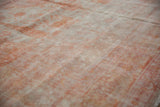Distressed pile texture of a Sivas carpet, with faded floral motifs in pale rust.