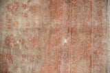 Detail of distressed Sivas carpet, showing pale rust motifs, exposed knot heads, and fringe.