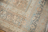 Distressed Meshed carpet corner, showing intricate floral motifs and time-softened hues.