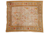 Antique Oushak carpet fragment, low pile with faded saffron, red, teal floral motifs.