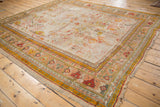 Antique Oushak fragment with worn rectilinear florals revealing foundation in saffron, rose, and silver.