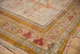 Antique Oushak carpet corner: saffron yellow, cherry red, dusty teal geometric borders, foundation wear.