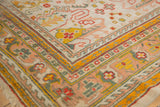 Antique Oushak rug corner with rectilinear floral designs and saffron, red, teal borders.