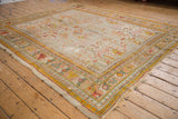 Worn fringe and corner detail of an antique Oushak rug with faded rectilinear floral design.