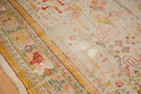 Antique Oushak rug's rectilinear border, displaying saffron yellow, cherry red, and worn foundation.
