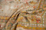 Detail of folded antique Oushak rug, showing visible wear, reinforcements, and saffron yellow geometric border.
