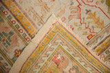 Worn foundation with visible reinforcement stitching on this antique Oushak fragment.