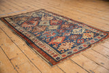 Antique Caucasian Kuba rug's indigo and madder red geometric guls, pinwheels, and fringe.