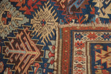 Antique Kuba rug detail: serrated guls, tree-of-life motifs, indigo, red, ivory border, with wear.