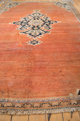 Vintage Mahal carpet lower border featuring terracotta field, navy and sky blue vine palmettes, and fringe.