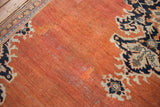 Terracotta abrashed field of a vintage Mahal rug showing pile wear, restoration, and navy motif.