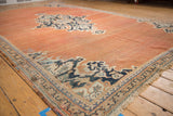 Vintage Mahal rug corner with low-pile terracotta field, navy palmette vine border, and fringe.