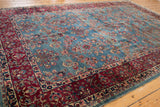 Vintage Kerman carpet's sky blue abrashes and millefleur field with wine red border.