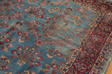 Vintage Kerman carpet detail: blue millefleur field abrashes and red vine main border.