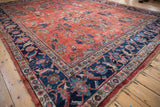 Distressed Mahal carpet's brick red field with bursting floral bouquets and navy Herati border.