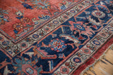Distressed vintage Mahal carpet, brick red floral field meets navy Herati design border.