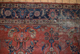 Brick red floral field and navy Mahi-Mahi Herati border of vintage distressed Mahal carpet.
