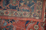 Distressed brick red field with foundation showing, bordered by blue and beige Herati design on vintage Mahal carpet.