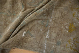 Distressed Sivas carpet detail: worn pile, exposed foundation, scattered holes, floral pattern.