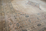 Distressed vintage Khorassan rug corner with intricate beige, navy, blush pawn borders.