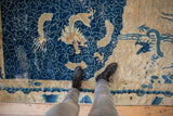 Distressed cobalt blue pictorial dragon and cloudband design on antique Peking rug.