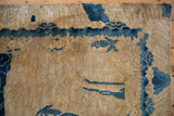 Aged distressed texture with cobalt blue wave border and pictorial fish motif on Peking rug.
