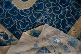 Antique Peking rug with distressed cobalt blue cloud motifs, revealing its woven foundation.
