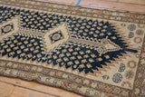Distressed navy field with beige boteh, serrated ivory edge, and patterned border detail.