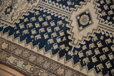 Navy blue field with beige boteh seeds and dramatic serrated ivory spandrel.