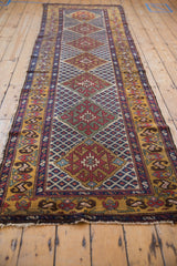 Angled perspective of a vintage Caucasian runner highlighting the single column of diamond medallions.