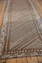 Lengthwise view of a distressed Hamadan rug runner showing its textured diagonal striations.
