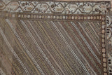 Corner detail showing the meandering vine border and even wear on the striped field.