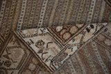 A folded corner reveals the hand-knotted construction and distressed pile of a vintage Hamadan runner.